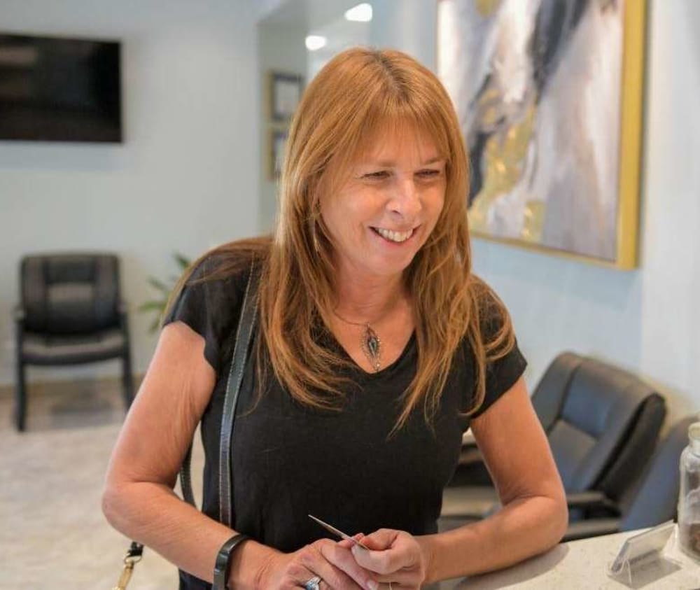 Smiling patient at the Hunter & King Dentistry reception desk.