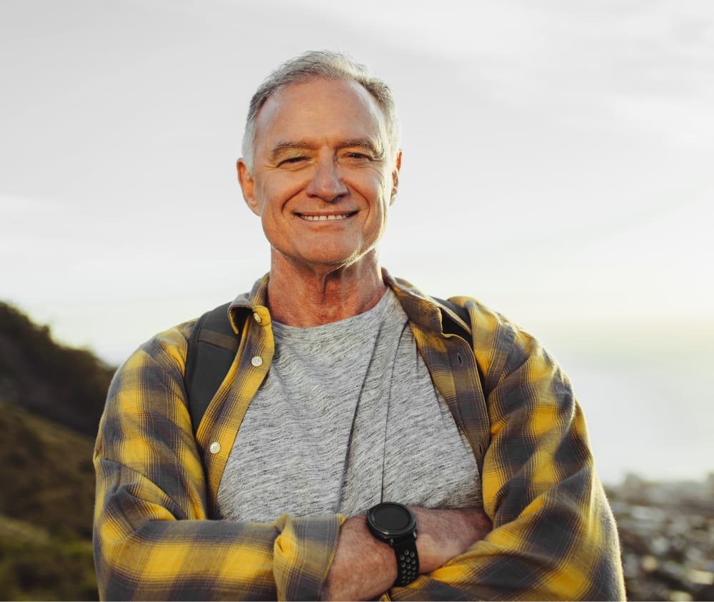 Senior adult enjoying the outdoors, smiling into the camera.